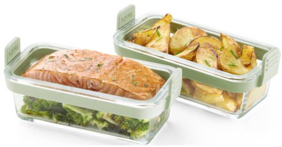 Twee glazen bakjes met groene deksels, één met zalm en broccoli, de ander met aardappelpartjes.