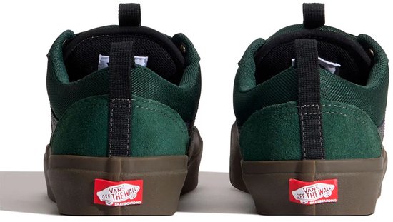Achterkant van twee groene Vans Old Skool sneakers met donkerbruine zolen en rode Vans-logo's op de hiel.
