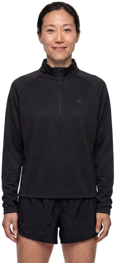 Vrouw met Aziatisch uiterlijk draagt een zwart sportshirt met halve rits en zwarte sportshort.