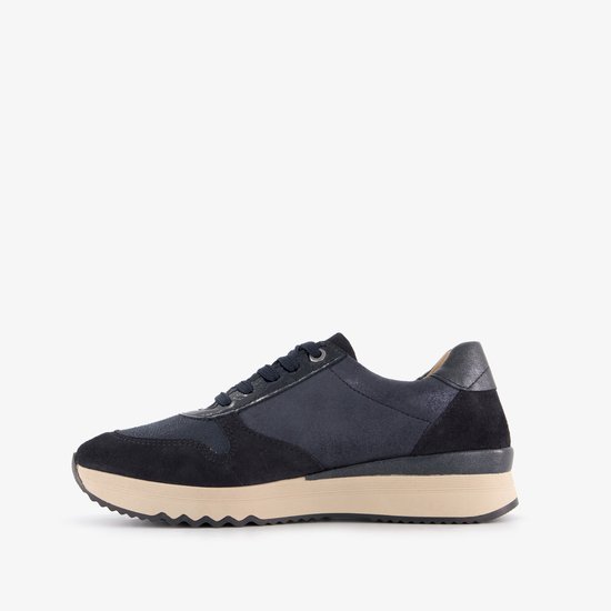 Zijaanzicht van een donkerblauwe suède sneaker met beige zool en veters.