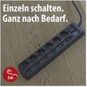 Zwarte stekkerdoos met 6 stopcontacten en individuele schakelaars, met tekst "Einzeln schalten. Ganz nach Bedarf."