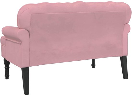 Roze fluwelen bankje met gecapitonneerde rugleuning en zwarte houten pootjes.