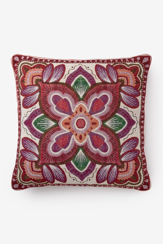 Kussen met een veelkleurig bloemendessin in rood, paars en groen.