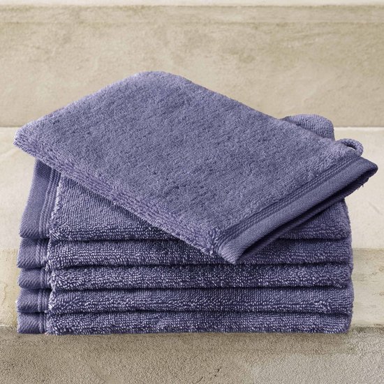 Stapel lavendelblauwe washandjes met een lusje, genomen in een studio.