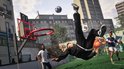 Voetballer maakt een omhaal bij een basketbalring in een buitenveld met gebouwen op de achtergrond.