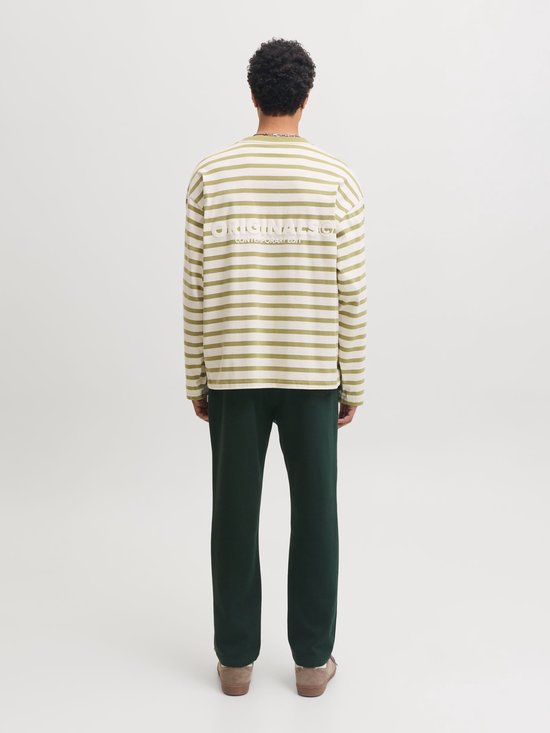 Man met rug naar camera, draagt groen-wit gestreept shirt met 'ORIGINALS' op achterkant.