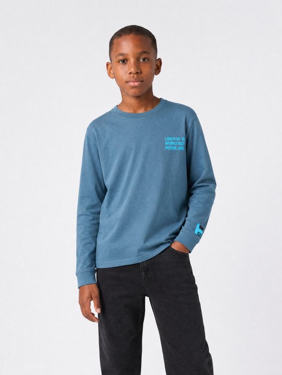 Jongen draagt een blauw longsleeve T-shirt met tekstprint op de borst en mouw.