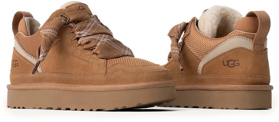 Twee bruine UGG sneakers met dikke zolen, wolvoering en veters met sneeuwvlokkenpatroon, naast elkaar.