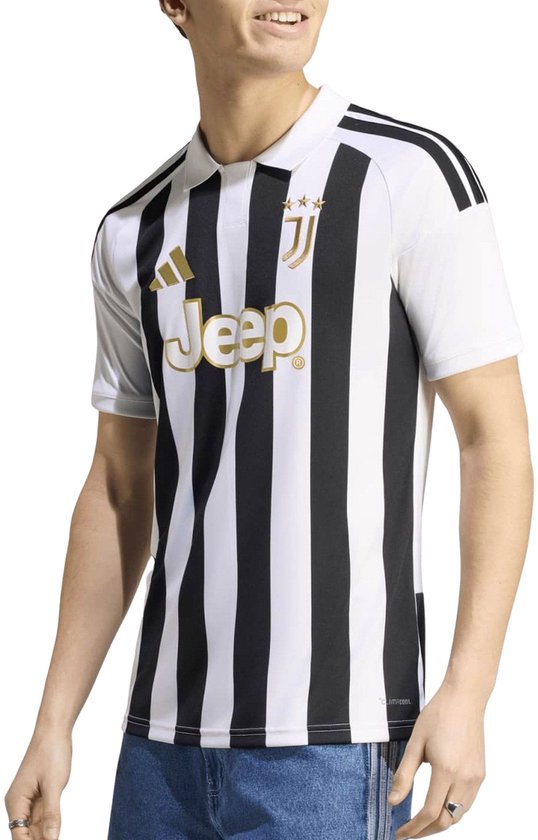 Man met krullend haar, draagt wit Juventus poloshirt met zwarte strepen en gouden logo's.