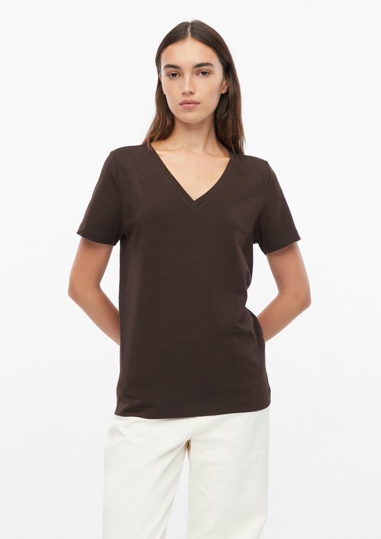 Model met bruin V-hals T-shirt, handen achter de rug