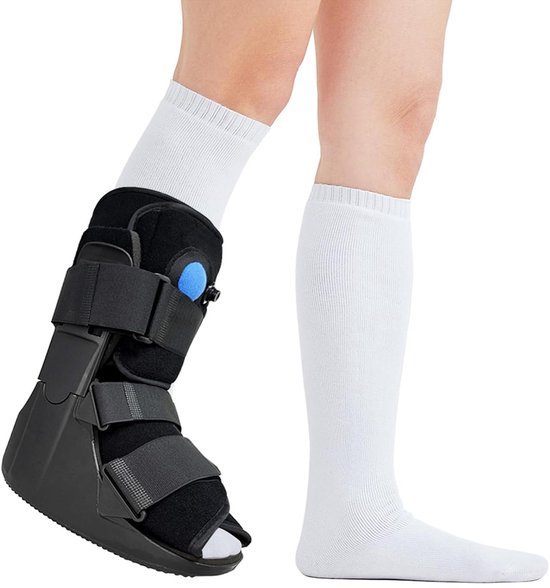 Een been draagt een zwarte enkelbrace met klittenband en een witte kniekous, het andere been draagt een witte kniekous.