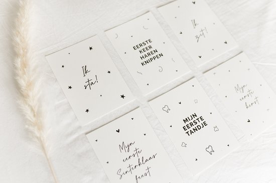 Baby mijlpaalkaarten met sterren en tekst zoals 'Ik sta!', 'Mijn eerste kerst', 'Eerste keer haren knippen', 'Mijn eerste tandje'.
