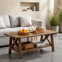 Rustieke houten salontafel met X-poten en opbergplank, met een mand met sinaasappels en een broodplankje.