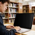 Jonge man met krullen werkt op een laptop in een bibliotheek, met een privacy screen.