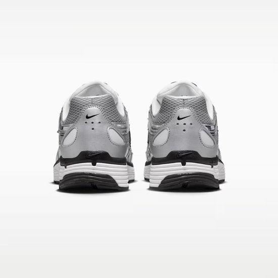 Achterkant van grijze Nike P-6000 sneakers. Zwarte zolen, witte tussenzolen en grijze mesh bovenkant met zwarte Nike logo's.