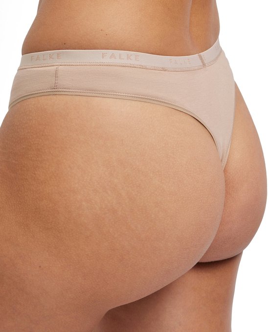 Achterkant van een model in beige Falke slipje met logo band.