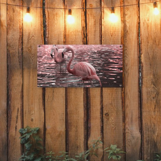 Tuinposter 80x40 cm - Tuindecoratie Een groep flamingo's staat in het water - Poster voor in de tuin - Buiten decoratie - Schutting tuinschilderij - Tuindoek muurdecoratie - Wanddecoratie balkondoek