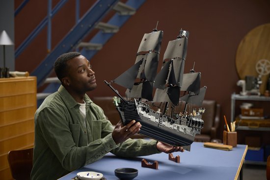 Un homme tenant le navire pirate LEGO du Capitaine Jack Sparrow.
