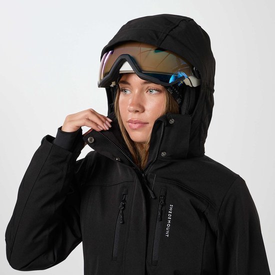 Close-up van een vrouw met skibril op haar gezicht en zwarte ski-jas.