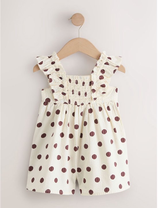 Crèmekleurige playsuit met bruine stippen, ruches en geplooide taille.