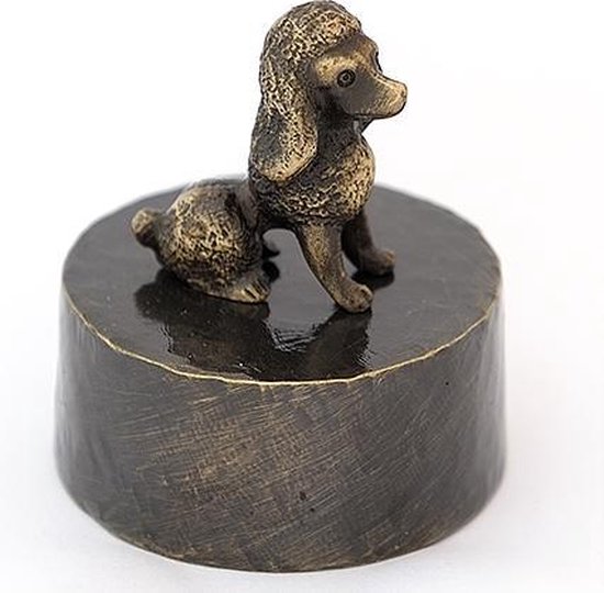 Petite statue en bronze d'un caniche assis sur un socle rond et sombre.