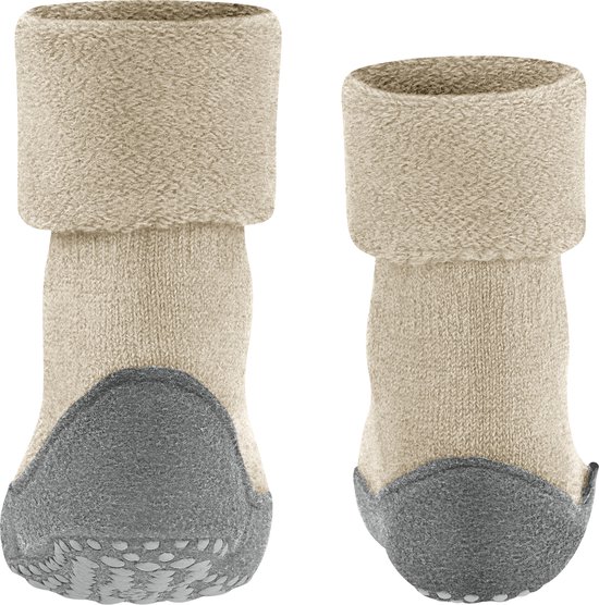 Achterkant van twee beige Falke huissokken met omgeslagen zandkleurige boord en grijze zool met antislip nopjes.