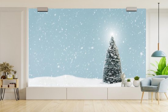 Behang - Fotobehang Een kerstboom in een besneeuwd landschap en een blauwe hemel - Breedte 525 cm x hoogte 350 cm