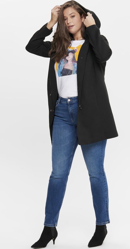 Vrouw in zwarte lange jas met capuchon en spijkerbroek.