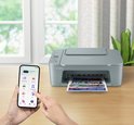 Grijze Canon Pixma printer met een smartphone met printopties in de buurt.