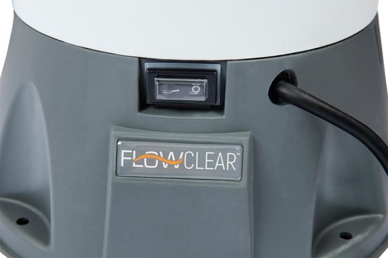 Close-up van de aan/uit-schakelaar en het Flowclear-logo op de grijze behuizing van een zandfilterpomp.