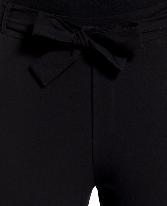 Detail van een zwarte broek met strikceintuur.