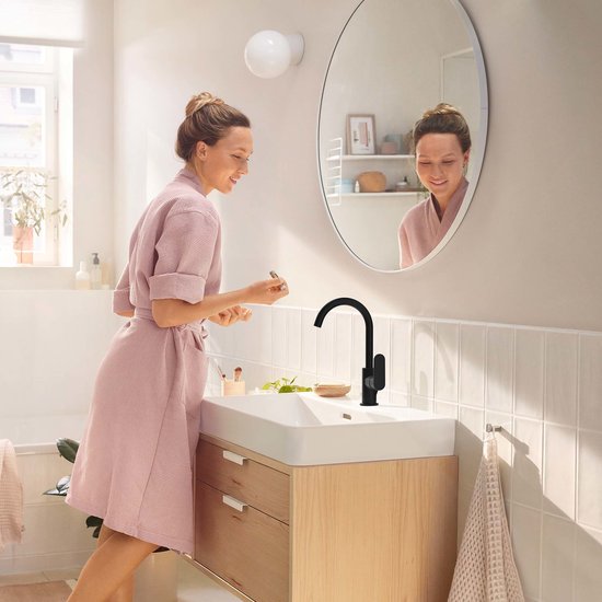 Matzwarte wastafelkraan met gebogen uitloop in een lichte badkamer.