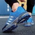 Blauwe hardloopschoenen met zilveren strepen en 'keep running' opdruk, gedragen door een persoon.