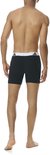 Model van achteren gezien in zwarte boxer briefs met witte tailleband en zwart Adidas-logo.