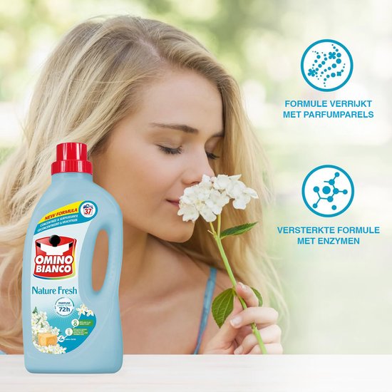 Een blonde vrouw ruikt aan een witte bloem, naast een fles Omino Bianco Nature Fresh. Iconen duiden aan: formule verrijkt met parfumparels, versterkte formule met enzymen.
