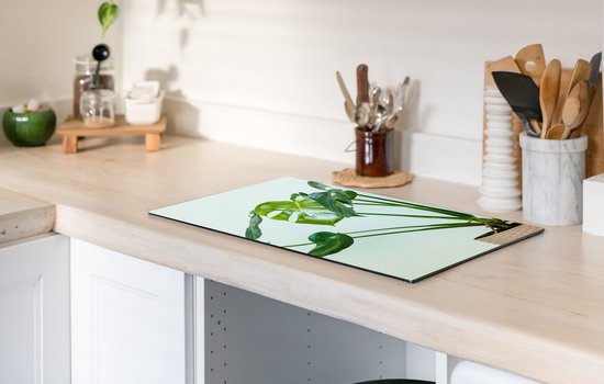 KitchenYeah® Inductie beschermer 30x52 cm - Monstera in een pot met een lichte achtergrond - Kookplaataccessoires - Afdekplaat voor kookplaat - Inductiebeschermer - Inductiemat - Inductieplaat mat