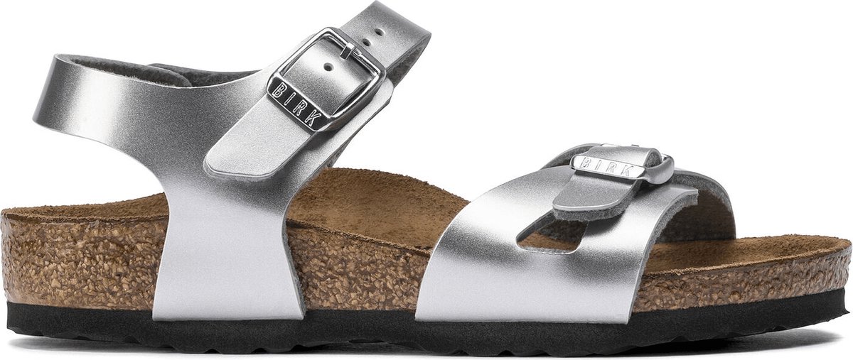 De Birkenstock Sandaal Rio 1019201 Metallic Zilver Smal, is een sandaal voor kinderen met een goed leren voetbed. De slipper heeft twee verstelbare banden voor een optimale pasvorm.Verder is zowel het bovenwerk als de voering gemaakt van Birko-Flor. De zool is gemaakt van het materiaal EVA. De slipper heeft een normale, tot smalle wijdte.EVA is een zacht, flexibel maar heel taai, UV- en weerbestendig, isolerend, licht van gewicht en slijtvast materiaal. Dit maakt EVA ten opzicht van het bekende PVC en rubber een veel effectiever en duurzamer materiaal. Een product van het materiaal EVA heeft zowel aan de buiten- als binnenkant dezelfde eigenschappen. (Als het materiaal EVA scheurt/breekt, neemt de binnenkant ook gn vocht op). - 0