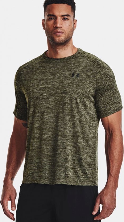 Man draagt een olijfgroen gemêleerd sportshirt van Under Armour met zwart logo op de borst.