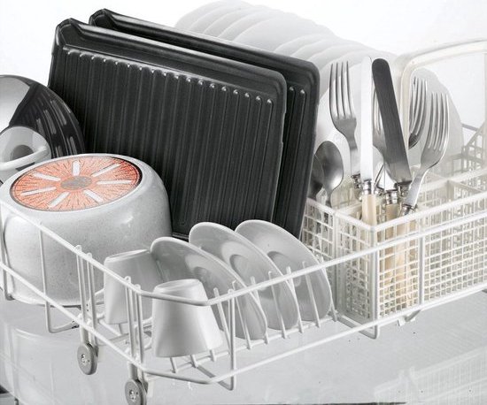 Vaatmand met servies, bestek en grillplaten.
