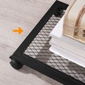 Detail van de onderste netwerkplank van een bijzettafel met wieltjes, met een schatkist en boeken.