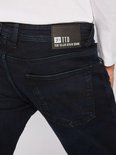 Donkerblauwe jeans met zwart leren label van Tom Tailor Denim Brand op de achterkant.