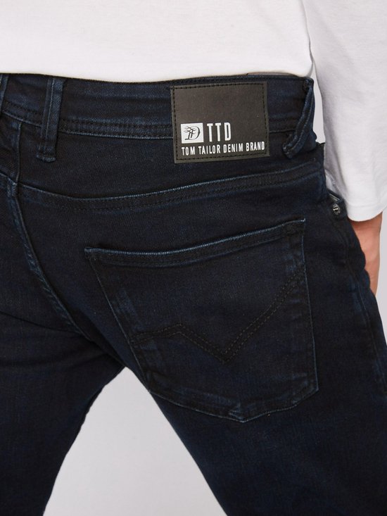 Donkerblauwe jeans met zwart leren label van Tom Tailor Denim Brand op de achterkant.