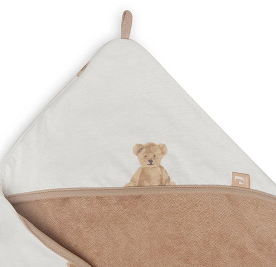 Une cape de bain blanche avec un bord beige et un imprimé d'ours brun, pliée.