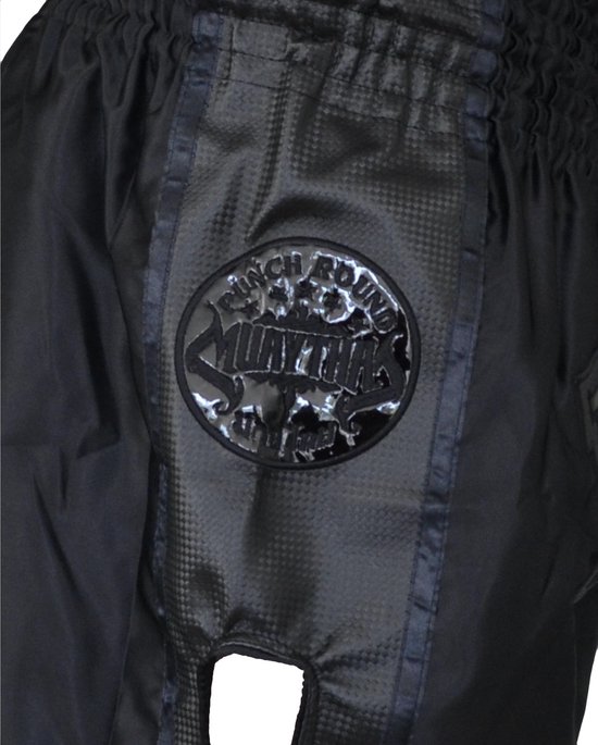 Detail van een zwarte Muay Thai short met 'PUNCH ROUND MUAY THAI' cirkelvormig logo en glanzende strepen.