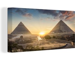 Canvas Schilderij Zonsondergang tussen de piramides van de Egyptische stad Caïro - 80x40 cm - Wanddecoratie