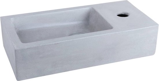 Lavabo rectangulaire en béton gris, vu de côté, avec un renfoncement pour le robinet.
