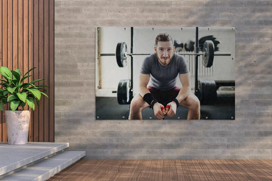 Portrait d'un haltérophile amateur assis sur son banc de musculation Affiche de jardin 180x120 cm - Toile de jardin / Toile d'extérieur / Peintures d'extérieur (décoration de jardin) XXL / Groot format!