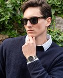 Man met zonnebril en donkerblauwe trui draagt een zilverkleurig Edifice Casio horloge.