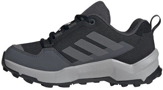 Zij-aanzicht van een zwarte Terrex wandelschoen met grijze Adidas strepen en een grijze zool.
