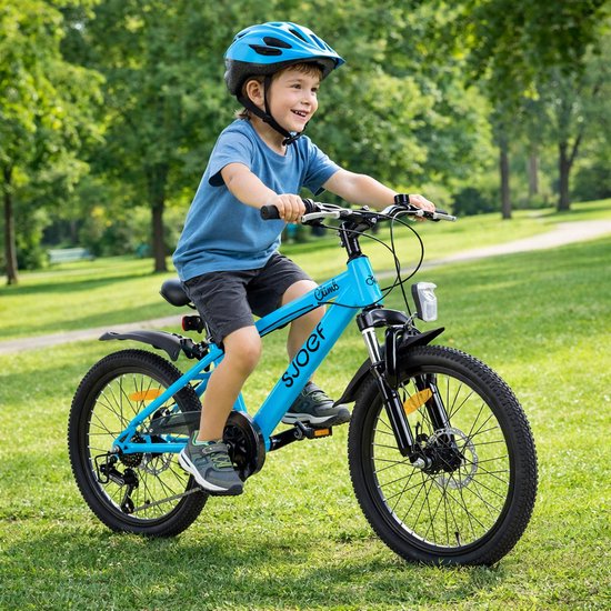 Jongen met blauwe helm rijdt op een felblauwe SJOEF kinderfiets in een park.